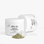 Jen-Au Greens Superfood Powder container with scoop on a white background